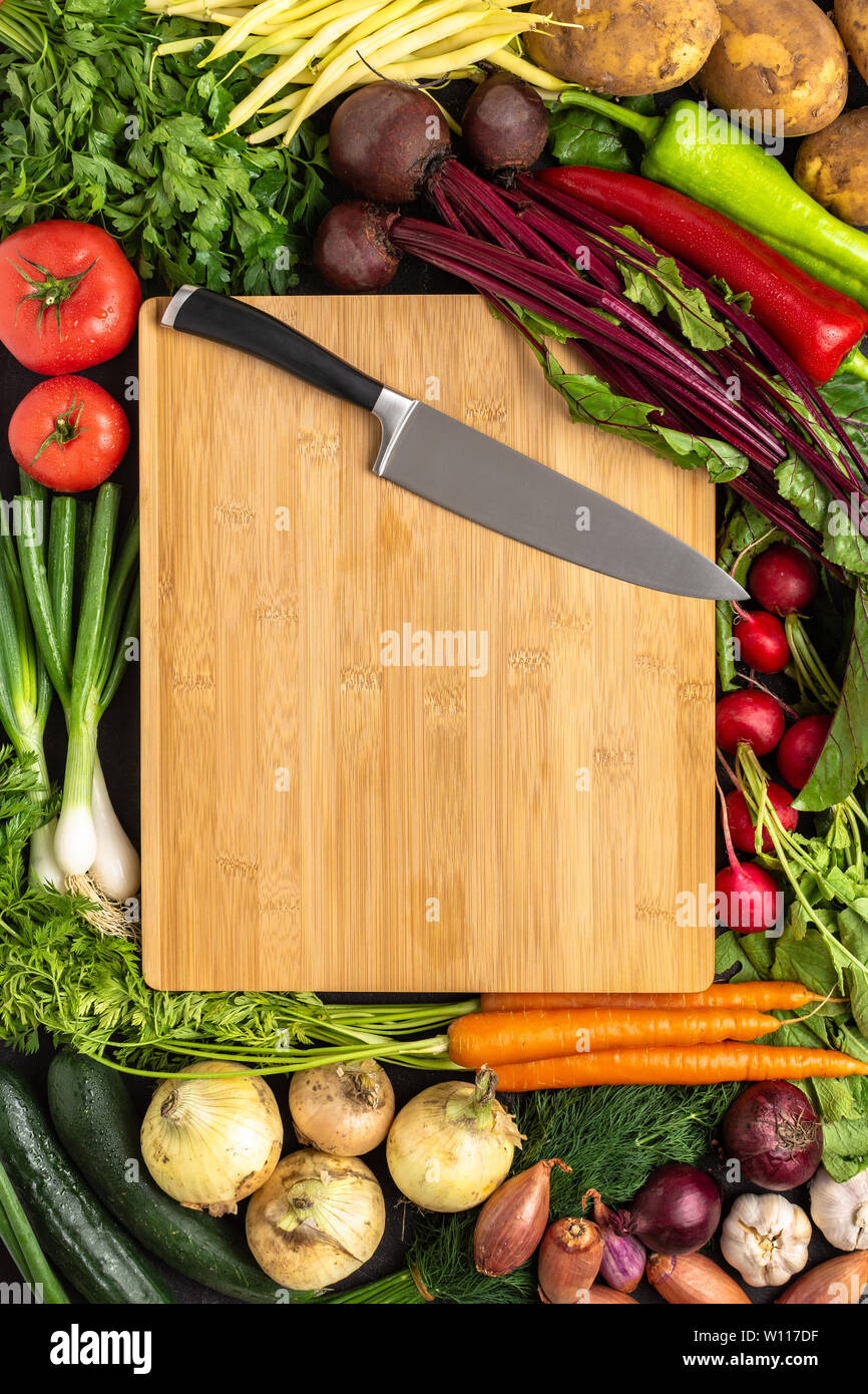 https://c8.alamy.com/comp/W117DF/chef-knife-on-wooden-chopping-board-with-fresh-vegetables-background-healthy-eating-concept-vegetarian-raw-food-W117DF.jpg