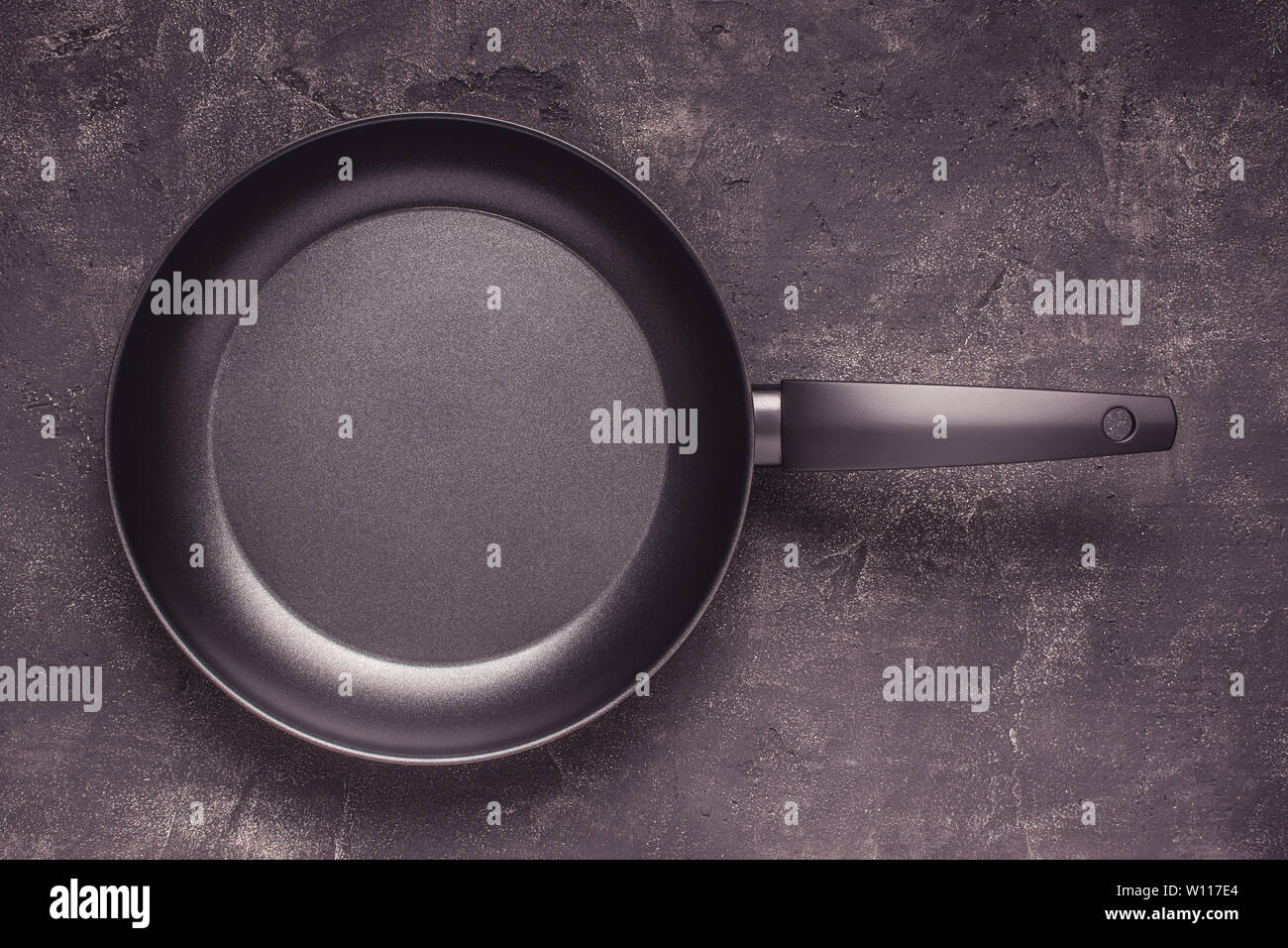 Kintchen Frying Pan on Dark Surface. Empty Culinary Background. Stock Photo