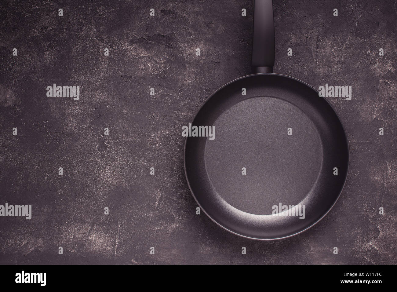 Kintchen Frying Pan on Dark Surface. Empty Culinary Background. Stock Photo