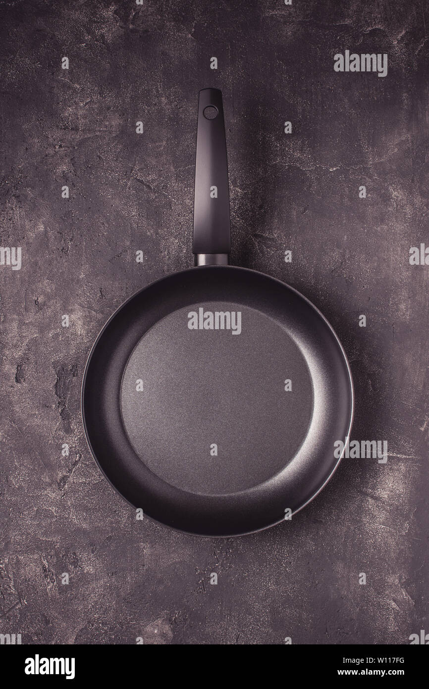 Kintchen Frying Pan on Dark Surface. Empty Culinary Background. Stock Photo