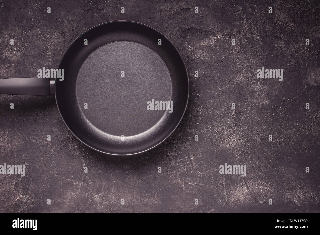 Kintchen Frying Pan on Dark Surface. Empty Culinary Background. Stock Photo