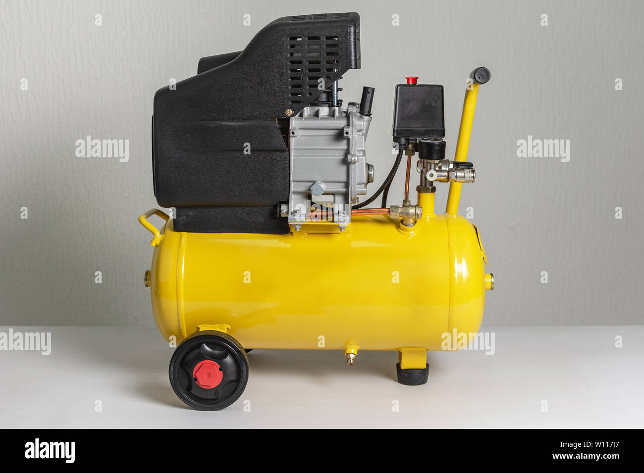 Yellow Piston Air Compressor. Compressing and Supplying Air Machine. Technical Equipment. Stock Photo