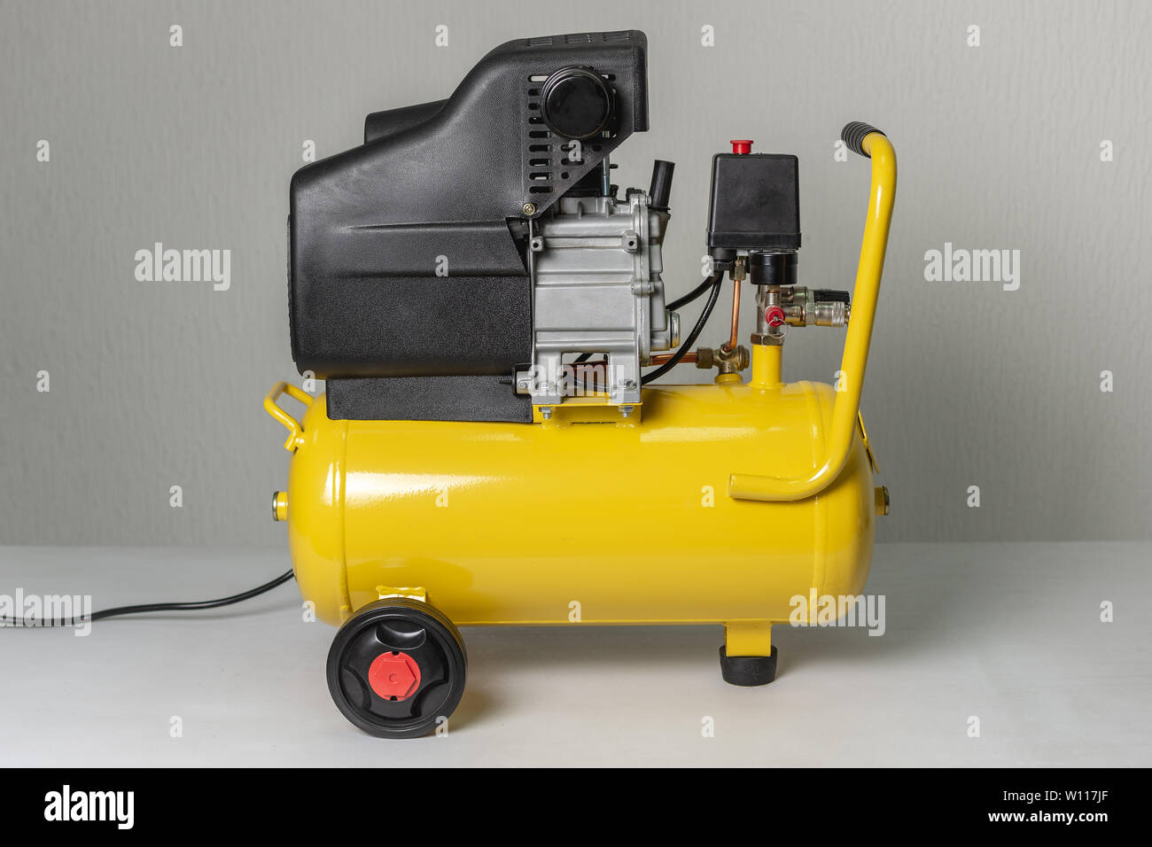 Yellow Piston Air Compressor. Compressing and Supplying Air Machine. Technical Equipment. Stock Photo