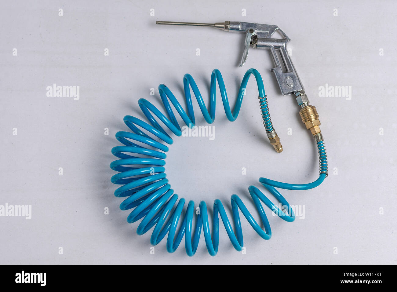 Air Compressor Blow Gun with Coiled Blue Hose on White Background Stock