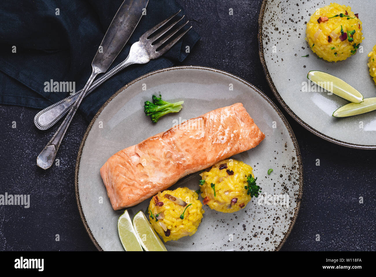 Grilled Salmon Steak with Yellow Risotto and Lime on Stone Background. Healthy Eating Concept. Stock Photo