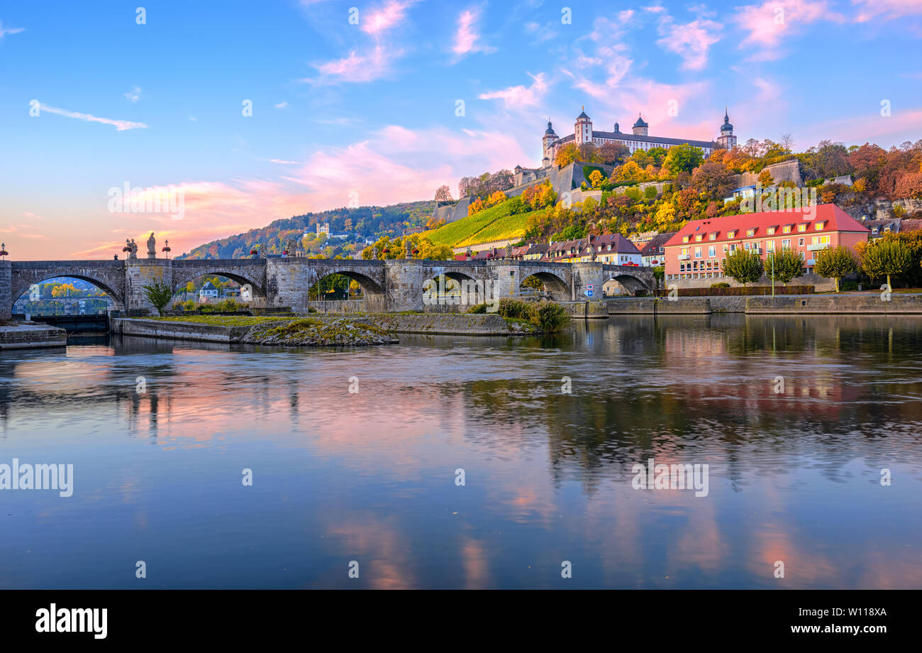 Wurzburg, Bavaria, Germany, view of the Marienberg Fortress and the Old Main Bridge reflecting in river on colorful sunrise Stock Photo