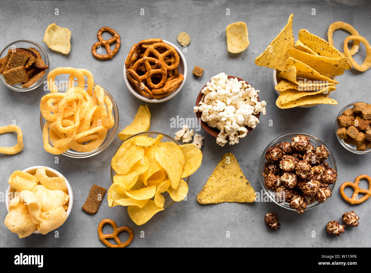 Assortment of Unhealthy Snacks chips, popcorn, nachos, pretzels, onion