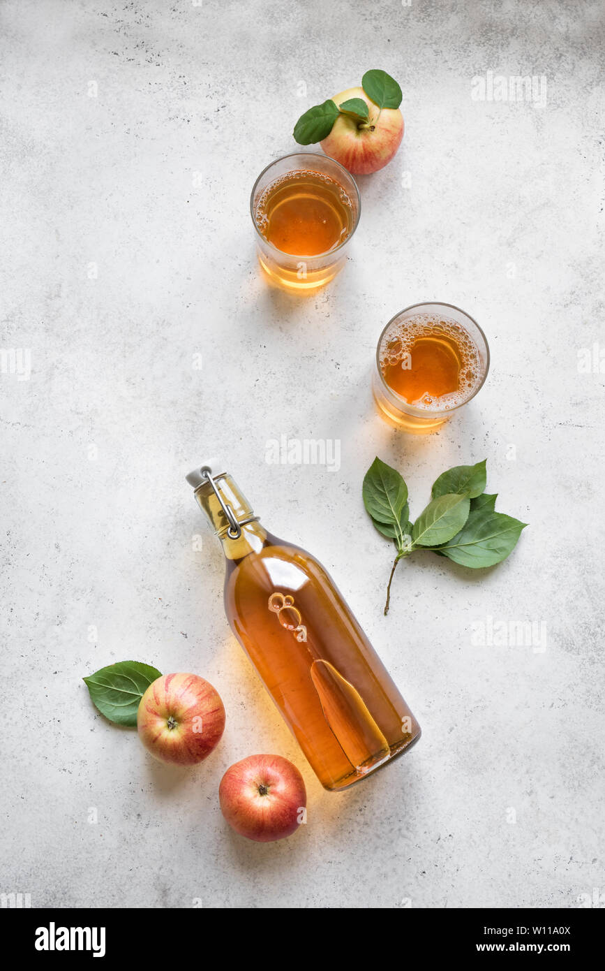 Apple cider drink or fermented fruit drink and organic apples on white