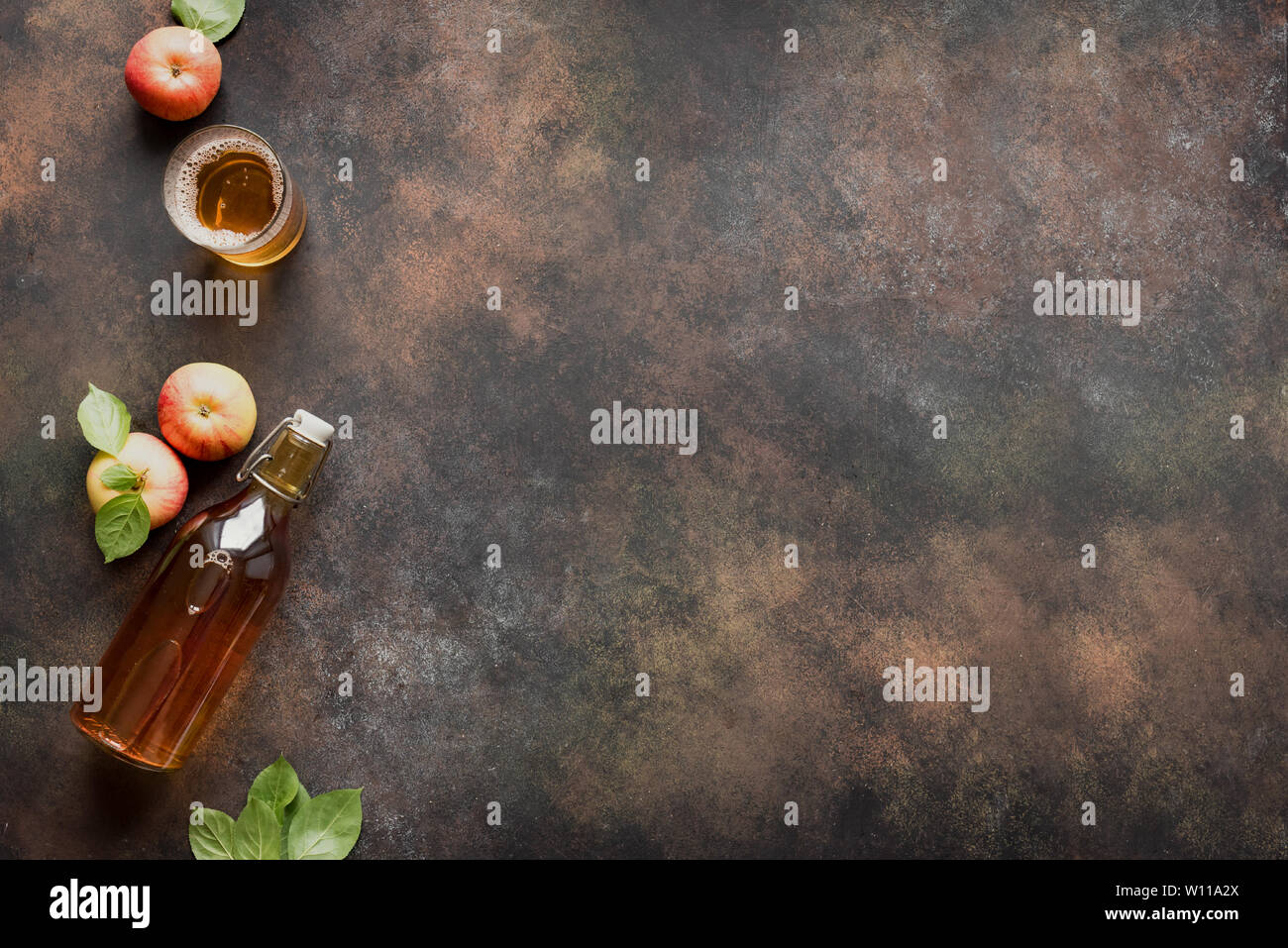 Apple cider drink or fermented fruit drink and organic apples on dark, top view, copy space. Healthy eating and lifestyle concept. Stock Photo
