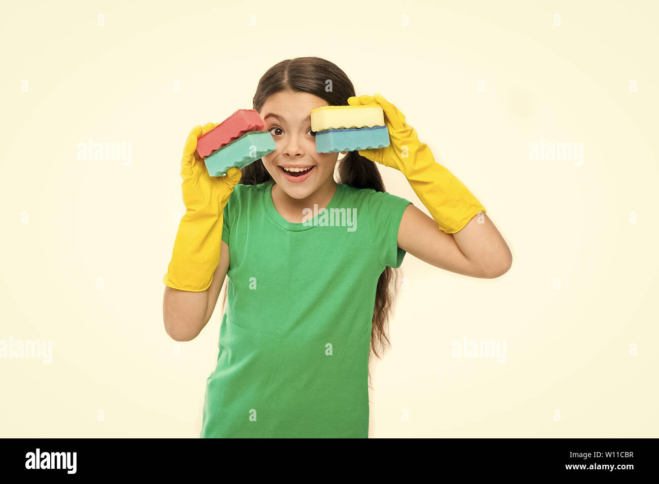 Set of cleaning sponges for her needs. Little housemaid ready for household help. Cleaning and washing up. Small housekeeper holding dish sponges in rubber gloves. Cute kitchen maid. Household duties. Stock Photo