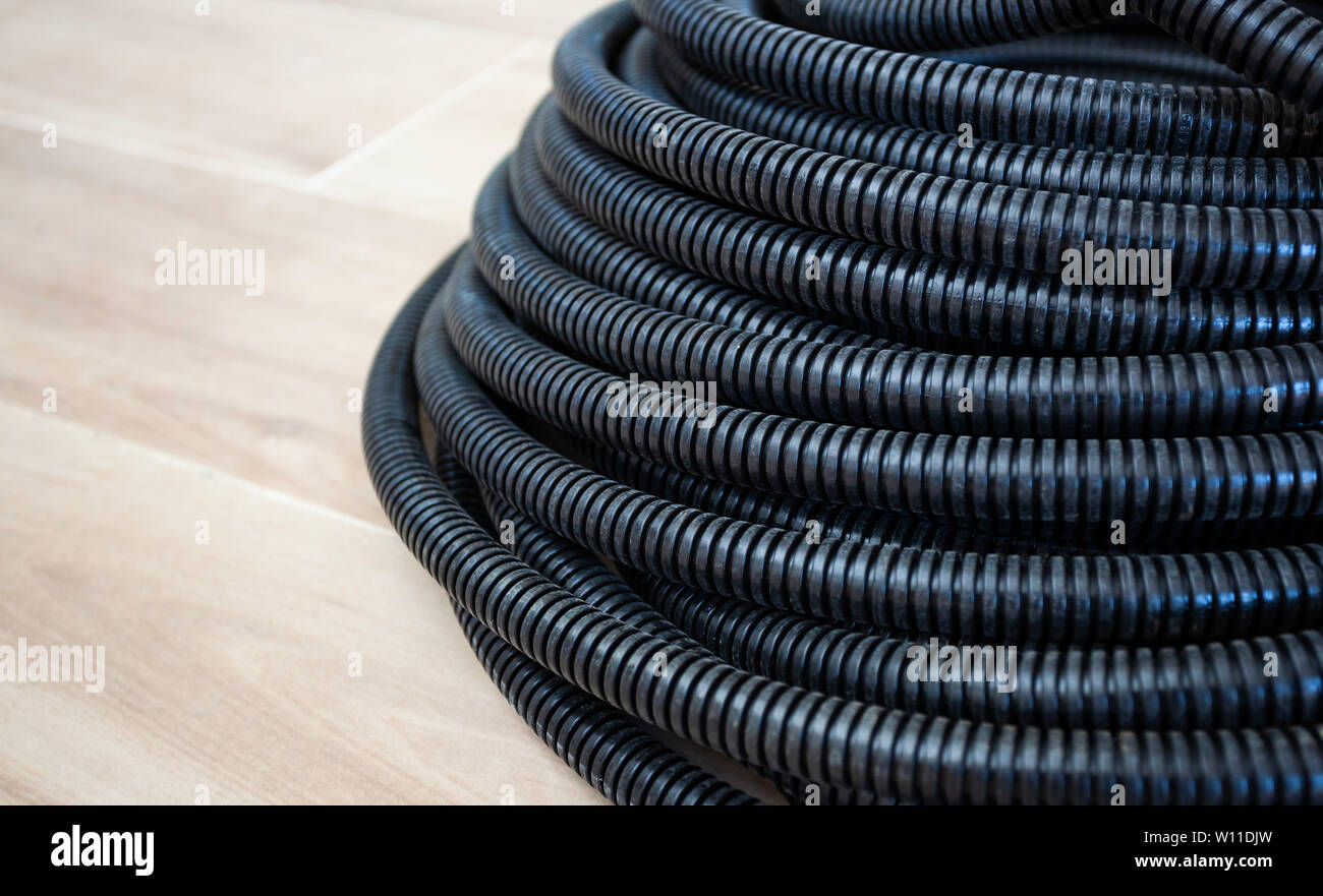 Black corrugated pipe for the cable. It is used for electrical installations. Stock Photo