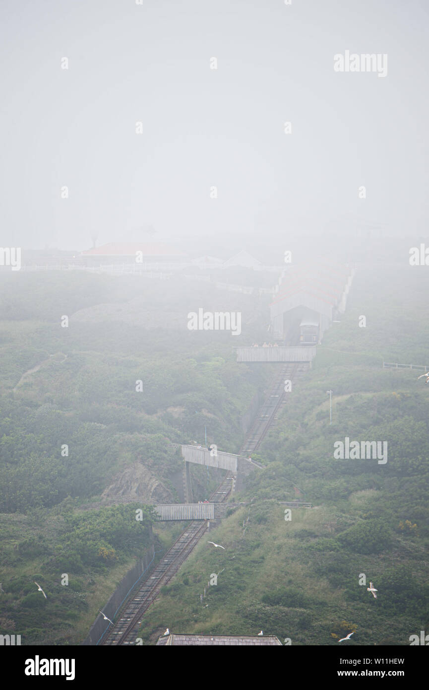 Aberystwyth, Wales, UK. Saturday 29 Jun 2019.  UK weather: As the south east of England is experiencing record breaking hot weather,  the distictive cliff railway in Aberystwyth on  the west coast of Wales is shrouded in low cloud and sea mist, keeping the temperatures substantially cooler.   Photo credit Keith Morris / Alamy Live News Stock Photo