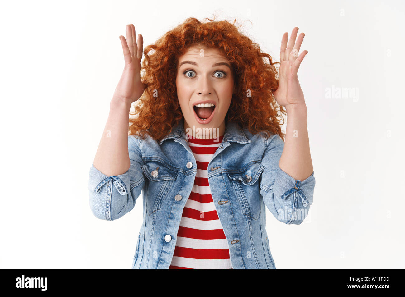 Amazed excited good-looking caucasian ginger girl screaming out loud impressed raising hands surprised emotive wide eyes hear amazing stunning positiv Stock Photo