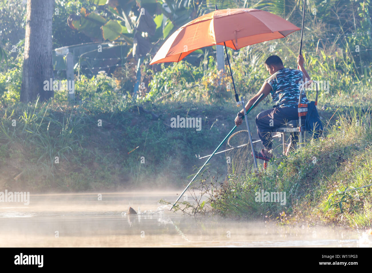 FANG,CHIANG MAI/THAILAND - DECEMBER 22,2018: Fishermen catch fish at the lake in the morning with beautiful sky Stock Photo