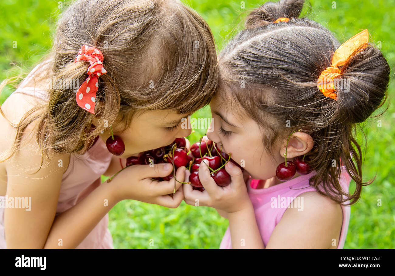 Children Eat Cherries In The Summer Selective Focus Stock Photo