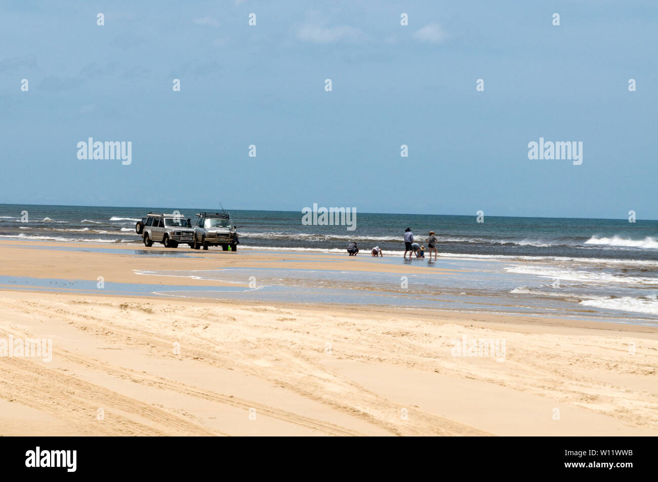 Two families searching for fishing bait on the 75 mile long Sandy Highway facing the Coral Sea on Fraser Island, Queensland, Australia  Fraser Island Stock Photo