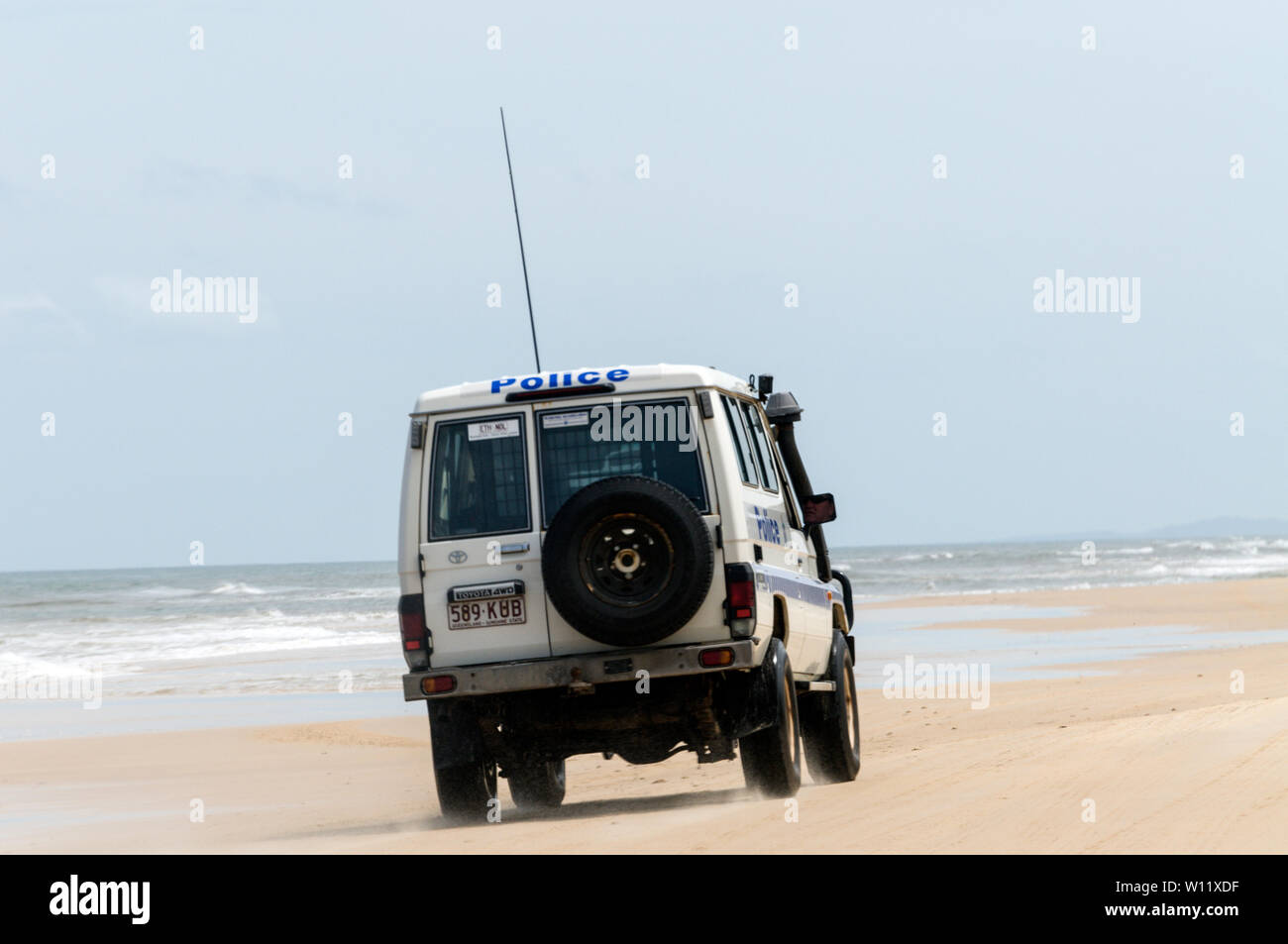 A Police vehicle patrolling part of the 75 mile long Sandy Highway on the east coast of Fraser Island in Queensland, Australia.   The Police enforce s Stock Photo