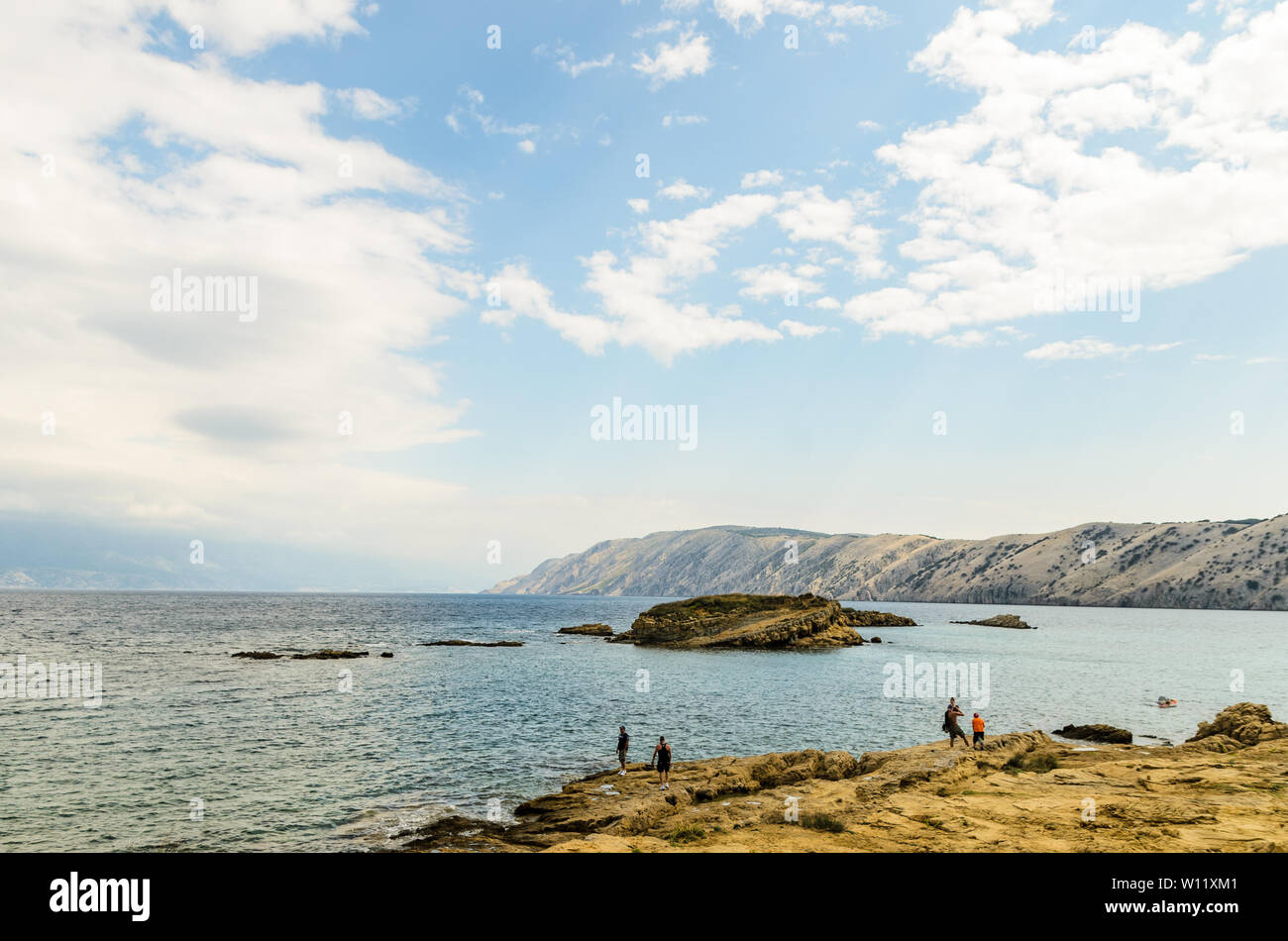 Rab Island, Primorje-Gorski Kotar / Croatia - 28 08 2014: View on a beach on a rab island with few tourists, Adriatic sea and mountains in distance Stock Photo