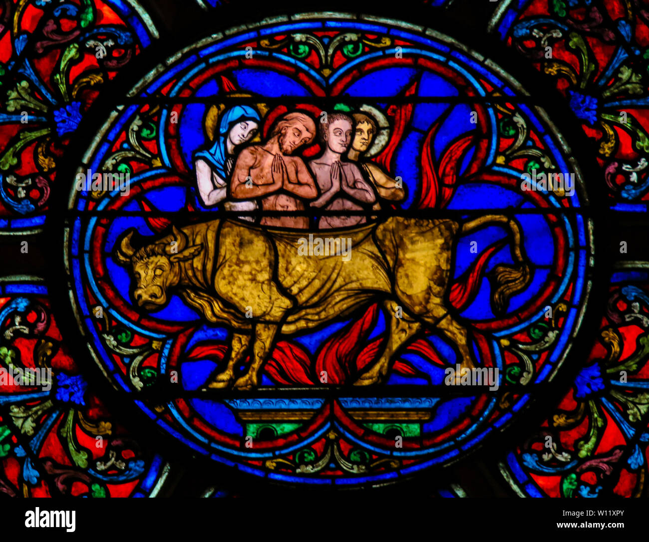 Stained Glass in the Cathedral of Notre Dame, Paris, France, depicting Saint Eustace, his Wife Theopista and their children, roasted to death inside a Stock Photo