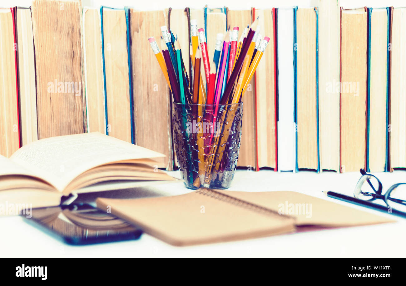 Open textbook, notebook, smartphone, stack of books education back to ...