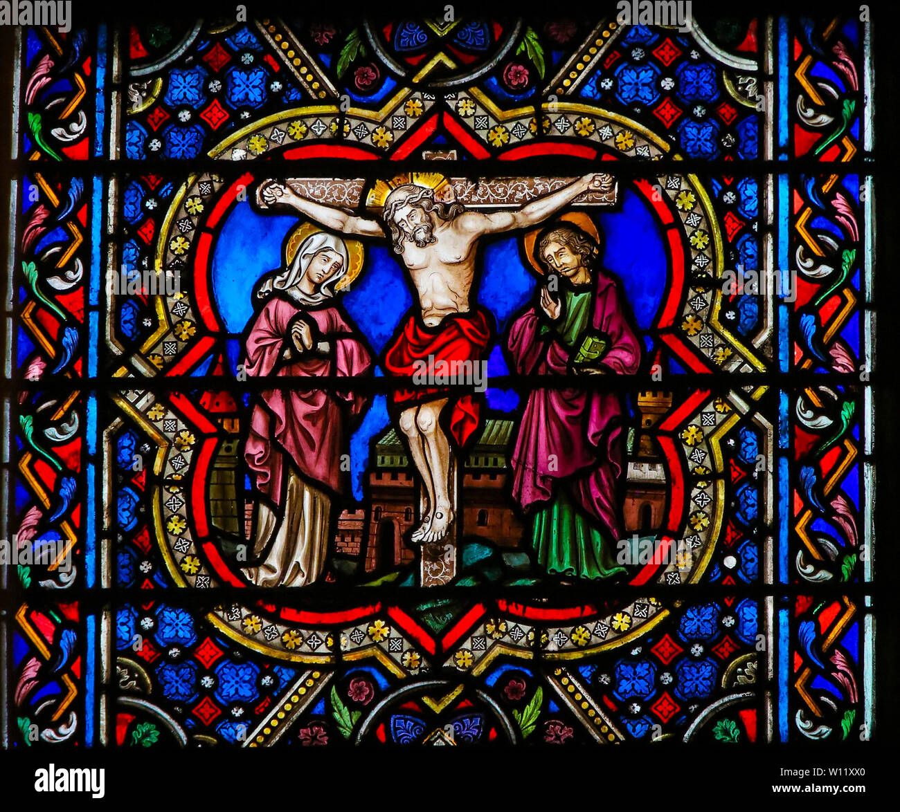 Stained Glass in the Cathedral of Notre Dame, Paris, France, depicting Jesus on the Cross, with St John and Mother Mary. Stock Photo
