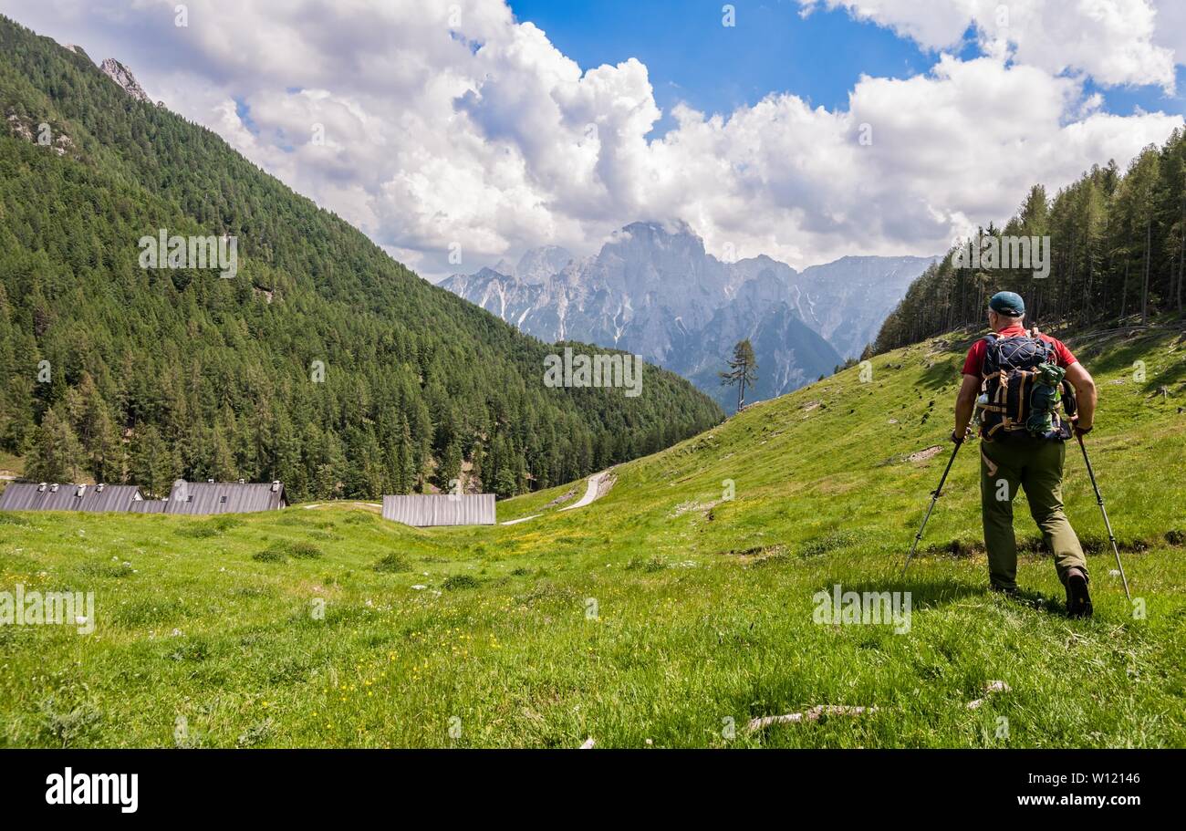 Hiker walk on trail and admiring the panorama. Italy Alps. Stock Photo