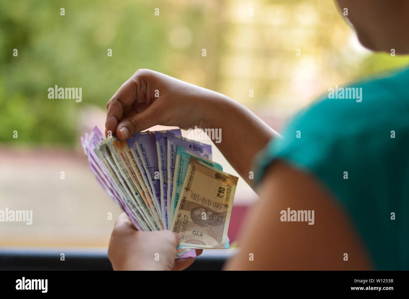 An Indian women holding all the colorful new released Indian Rupees currency notes in her hands after demonetisation in denominations Stock Photo