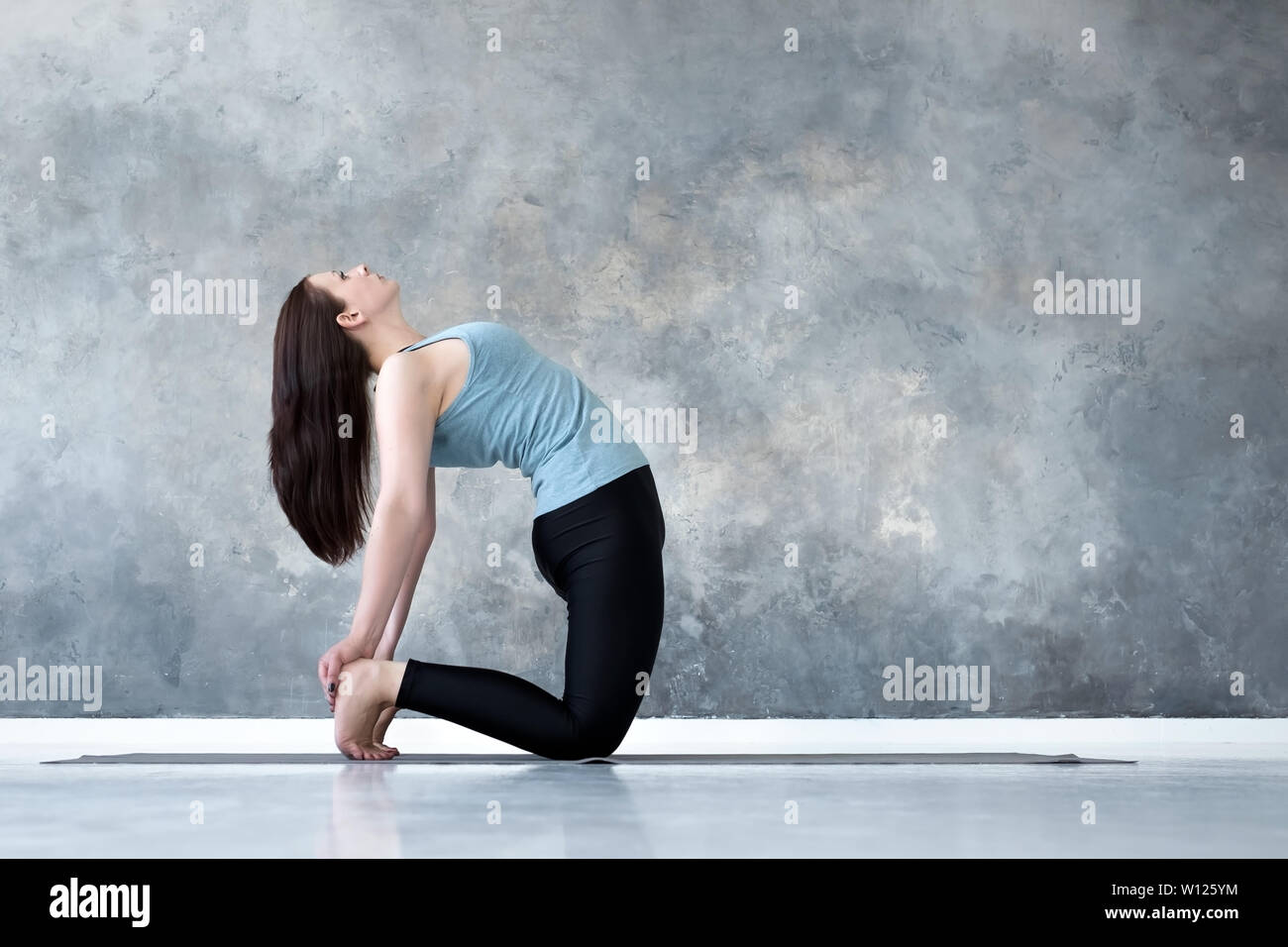 Sporty beautiful young woman practicing yoga, doing Ushtrasana, Camel ...