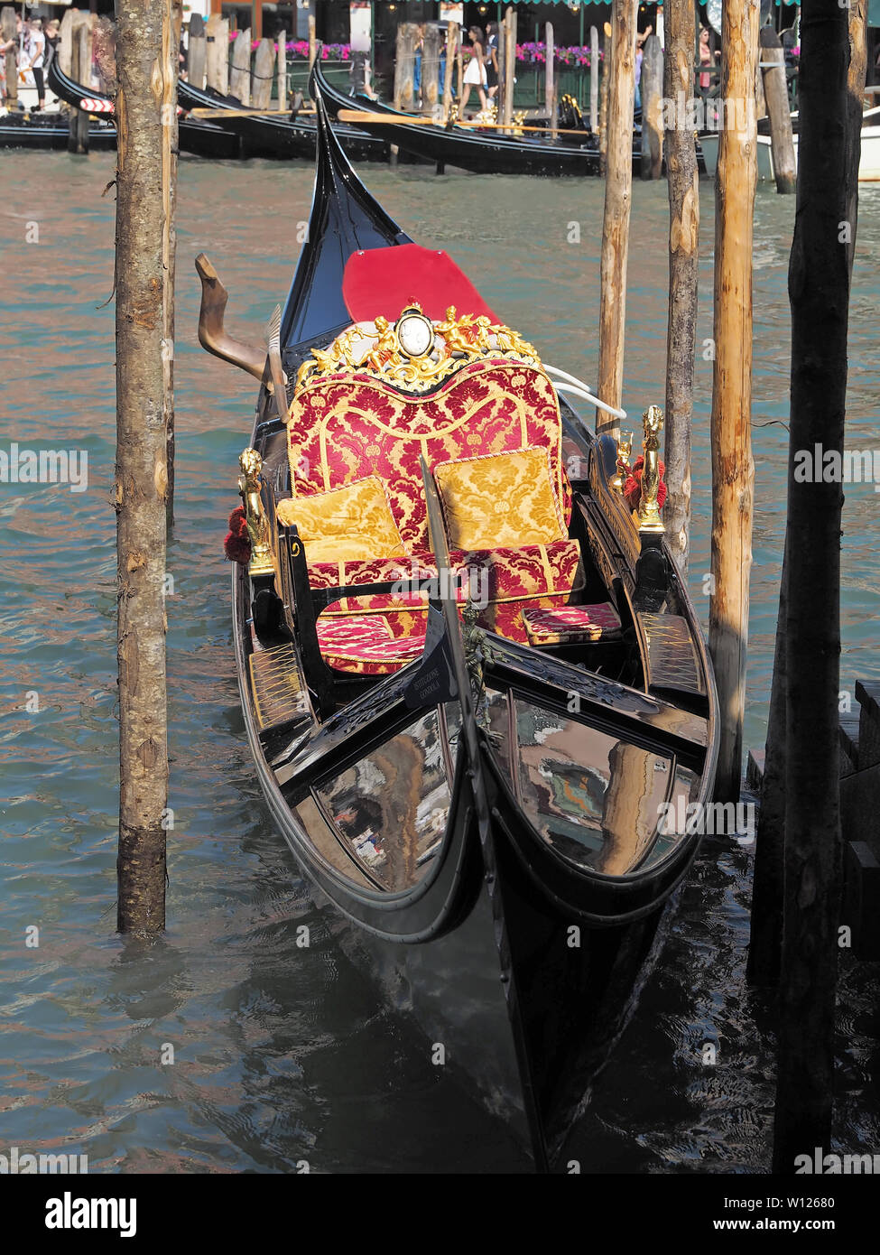 Gondola in Venice in Italy with cozy seats, ornaments, statues and ...