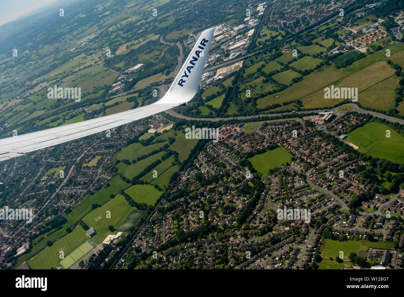 Aerial photograph of Manchester from a jet plane view of a Ryanair Boeing 737 - 800 wing out of plane window in flight Stock Photo
