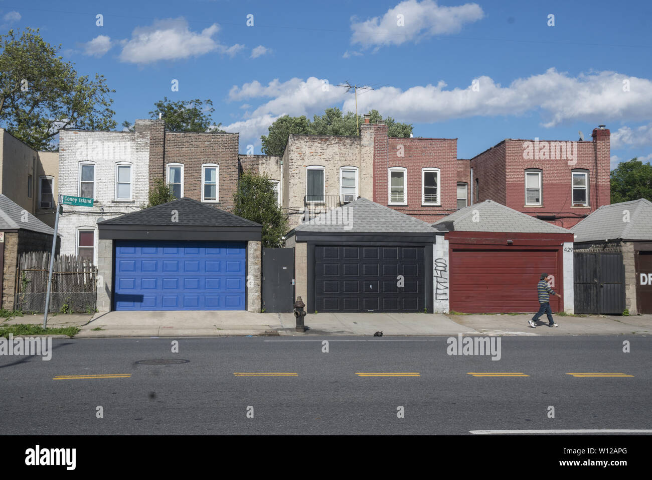 Garages along Loney Island Avenue with small apartment buildings on the