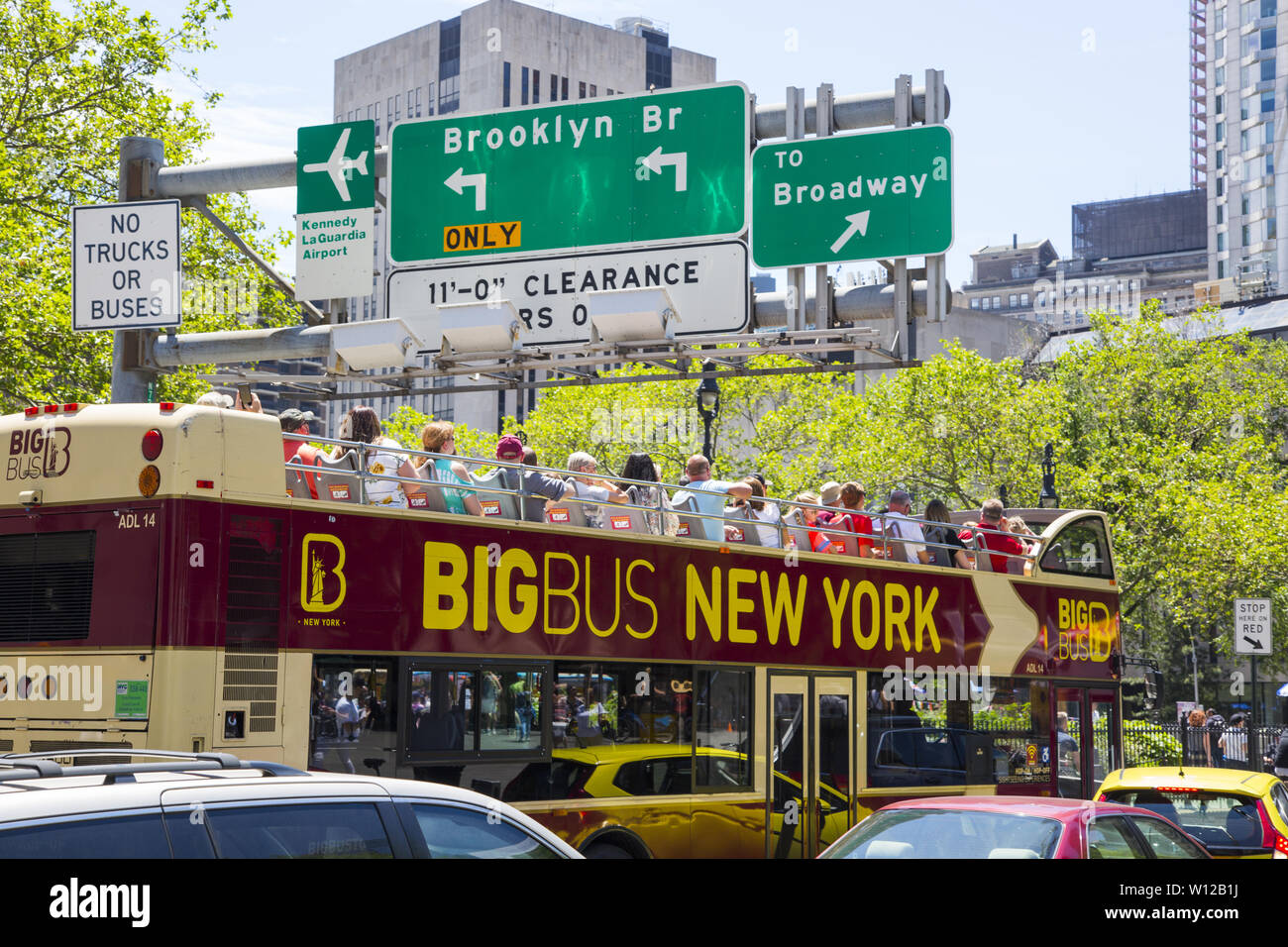 Tour bus at the entrance to the Brooklyn Bridge. Traveling by bus or on foot, crossing the Brooklyn Bridge is a popular tourist attraction in New York City. Stock Photo