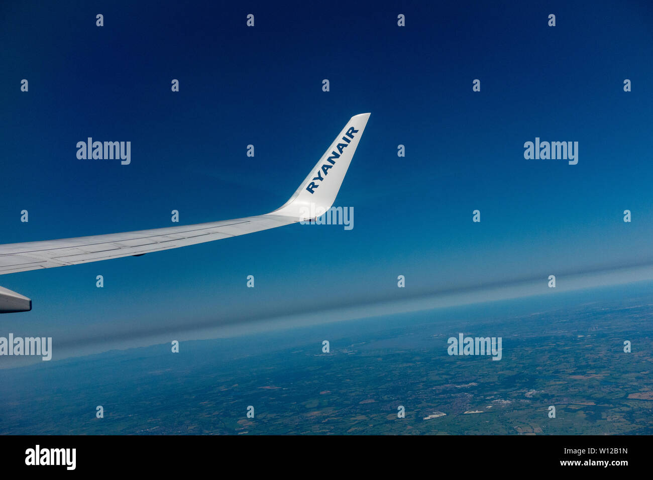 A Ryanair 737 - 800 wing and wing tip with the French Mediterranean horizon below Stock Photo