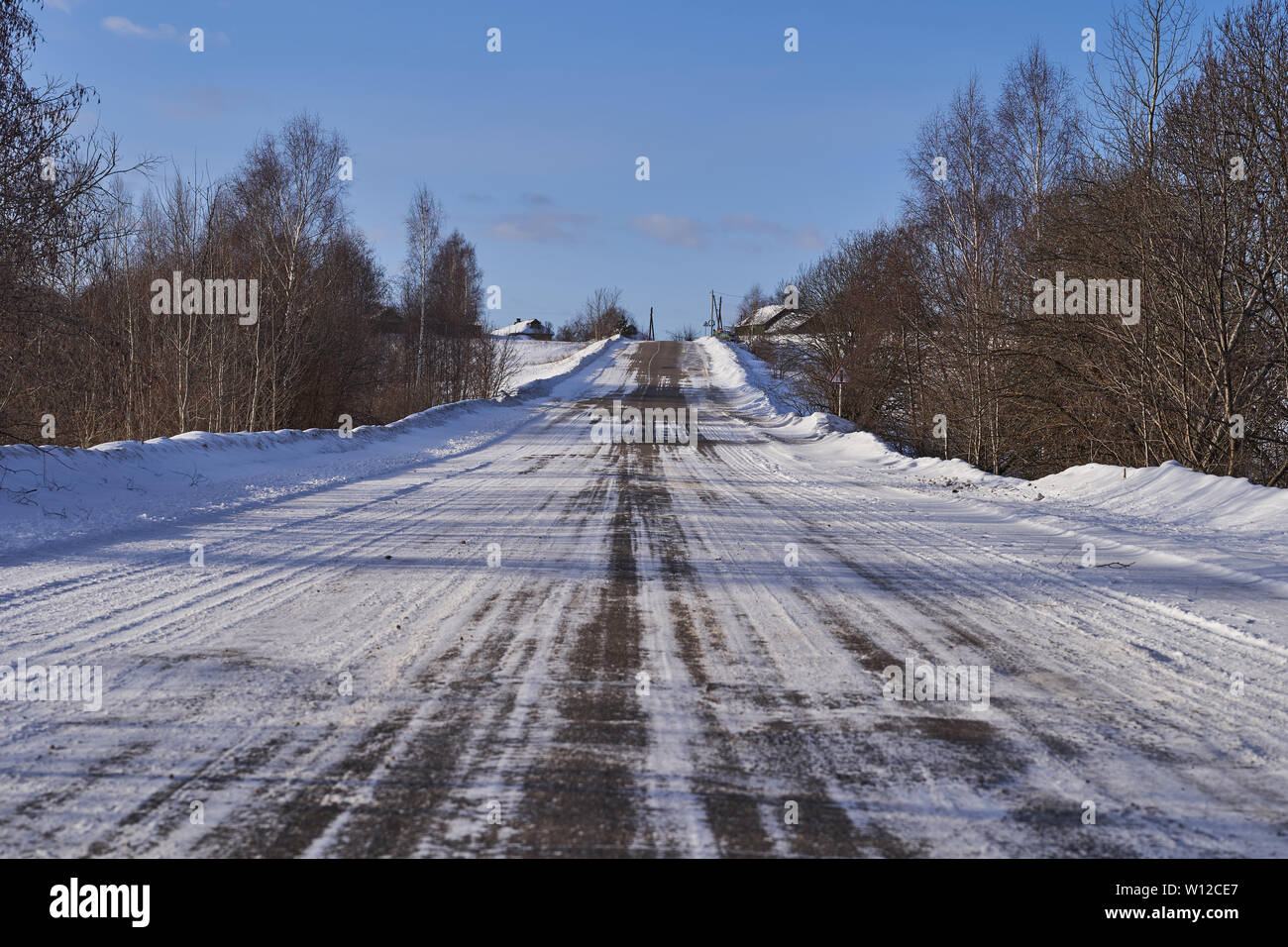 Winter road with asphalt, partially covered with snow Stock Photo - Alamy