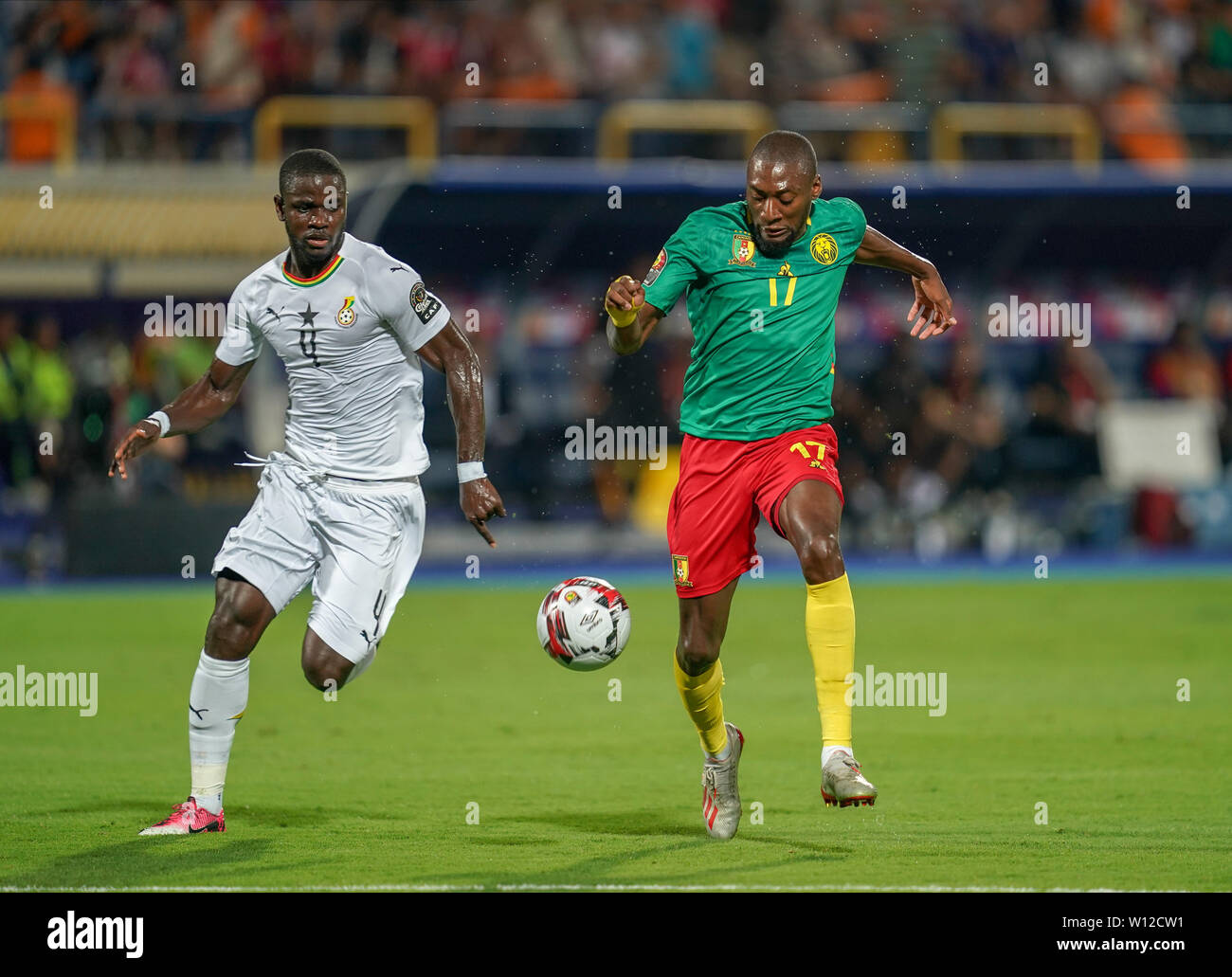 Ismailia, Egypt. 29th June, 2019. Karl Brillant Toko Ekambi of Cameroon and Jonathan Mensah of Ghana challenging for the ball during the 2019 African Cup of Nations match between Cameroon and Ghana at the Ismailia stadium in Ismailia, Egypt. Ulrik Pedersen/CSM/Alamy Live News Stock Photo