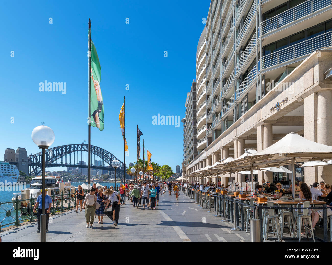 Cafes, bars and restaurants on Circular Quay looking towards the Sydney Harbour Bridge, Sydney, Australia Stock Photo