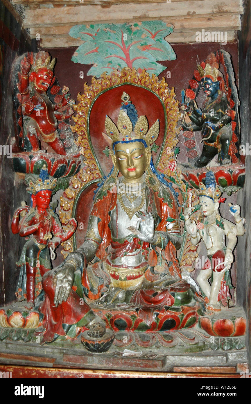 Ancient sacred statue of a deity with a silvery body in a Tibetan ...