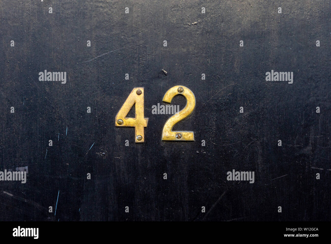 The answer is house number 42 with the forty two in bronze Stock Photo