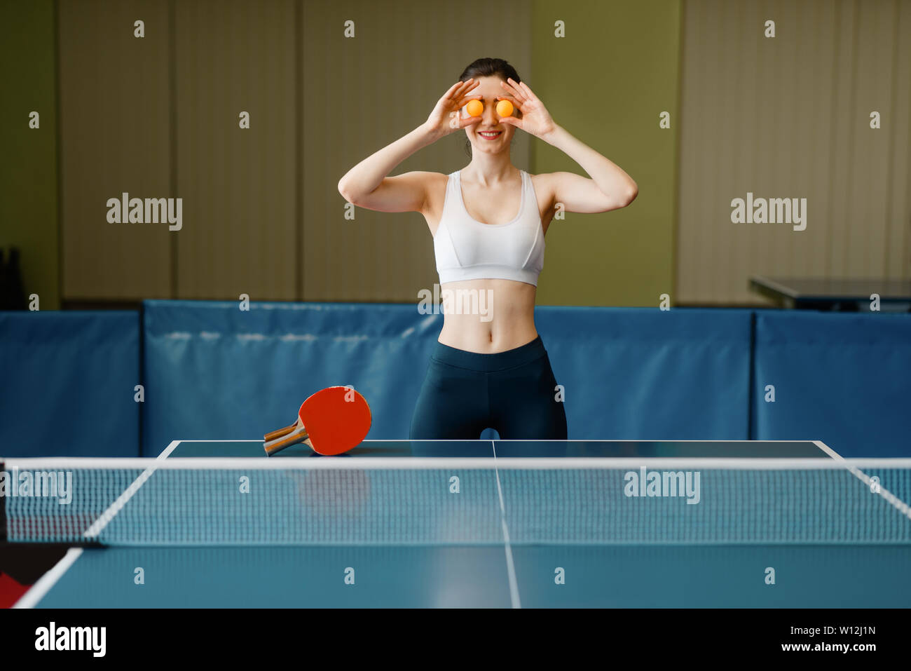 Young Woman Puts Ping Pong Balls To Her Eyes Stock Photo