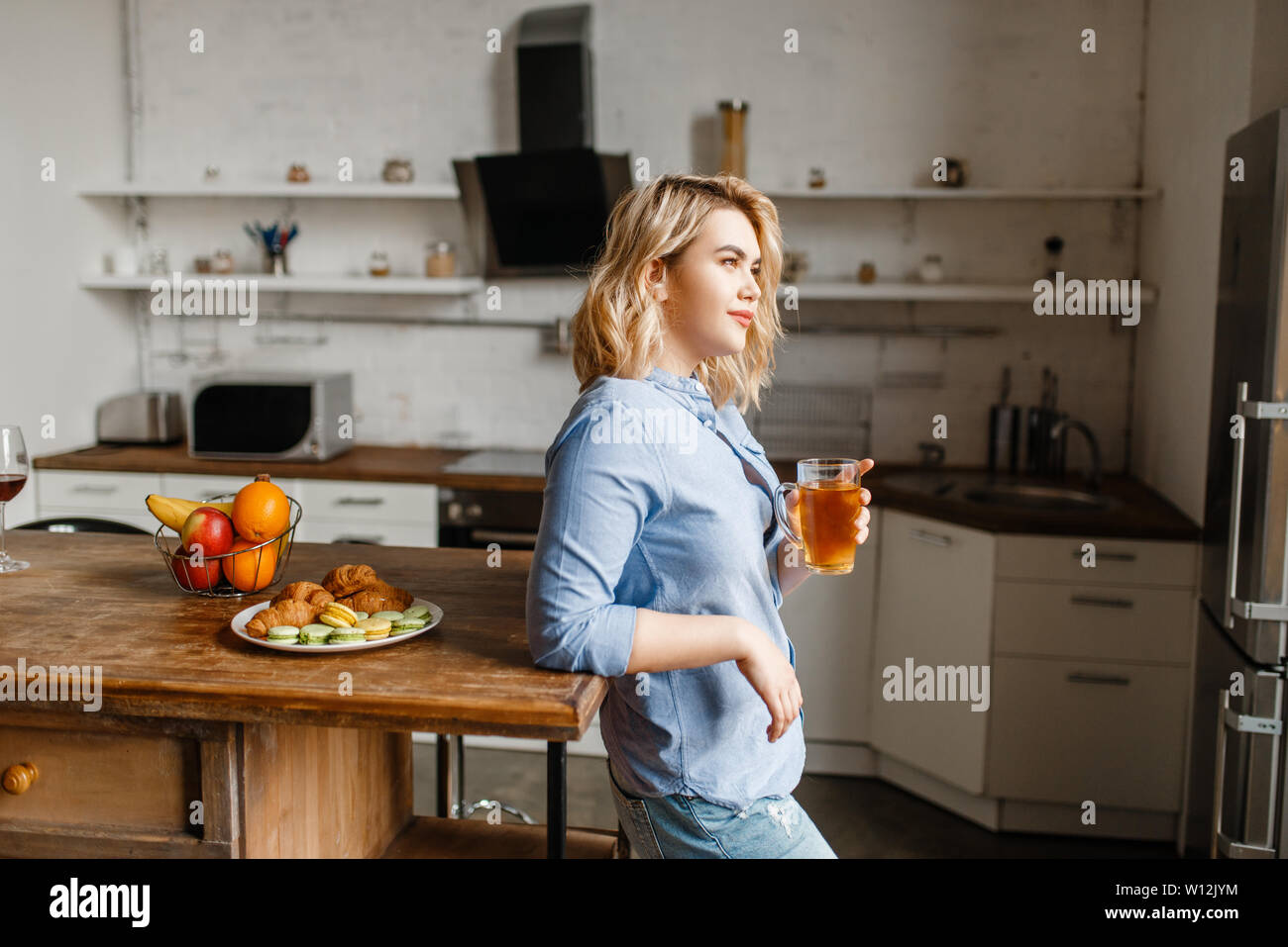 Woman having breakfast with croissants and cookies Stock Photo