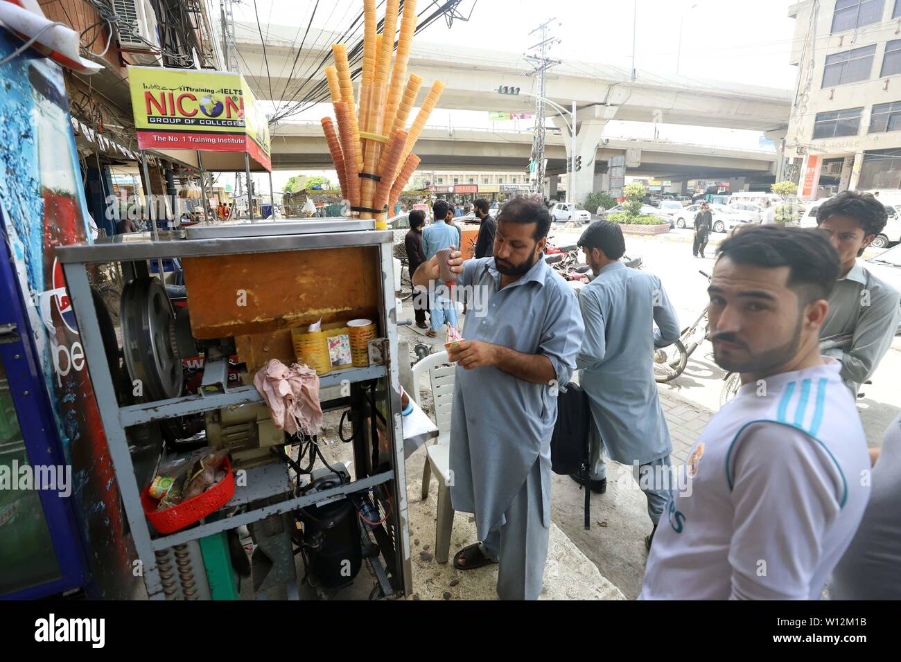 Rawalpindi, Pakistan. 29th June, 2019. A vendor prepares ice cream