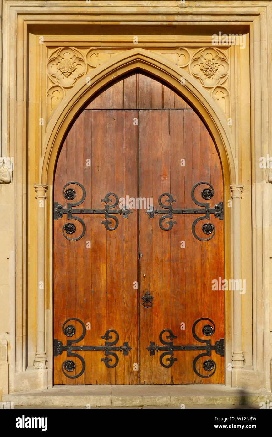 Old arched wooden church door with stone framework and metal ornaments Stock Photo