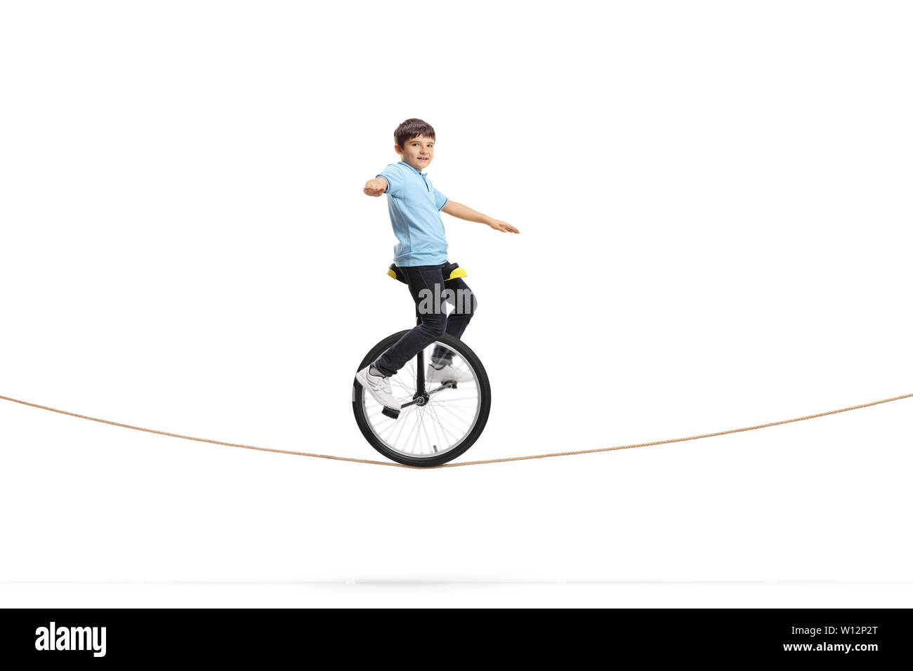 Full length shot of a boy riding a unicycle on a rope isolated on white background Stock Photo