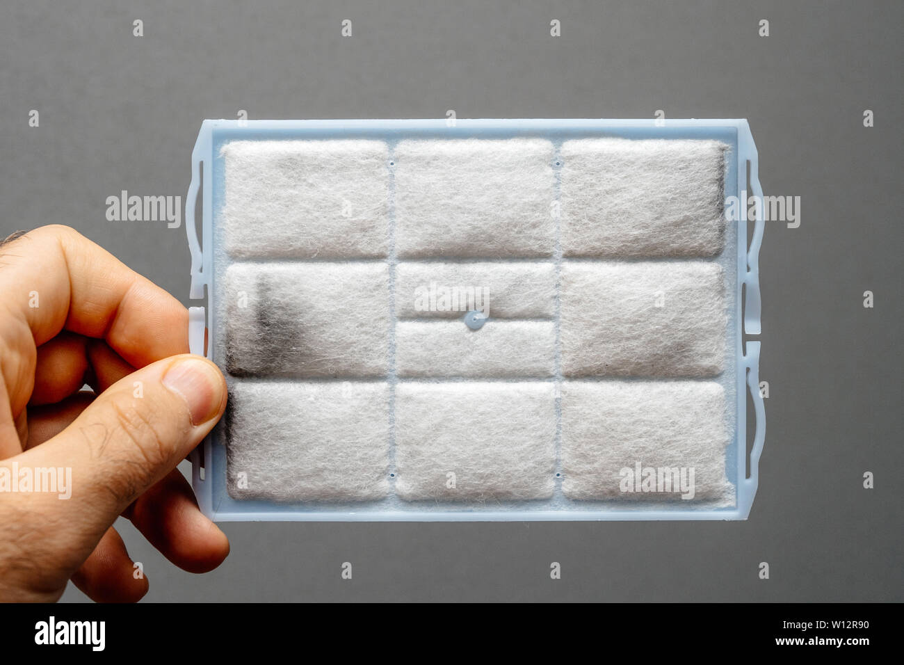 Man hand holding modern vacuum cleaner hepa filter in hand full with