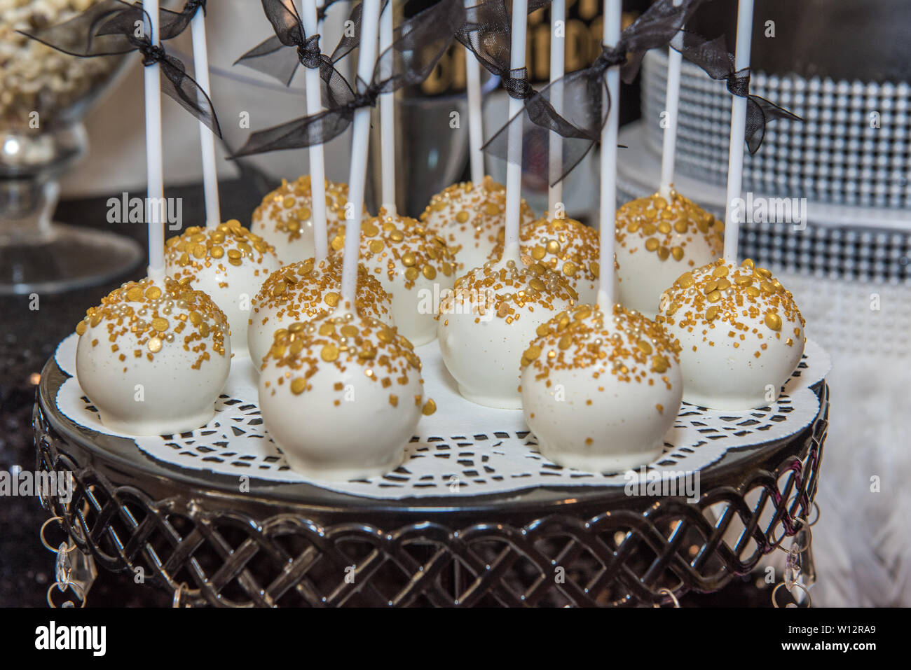 White frosted cake pops arranged on platform and ready for party goer to eat delicious dessert.. Stock Photo