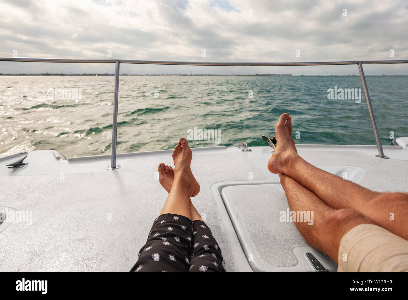 Yacht boat lifestyle couple relaxing on cruise ship in Hawaii holiday . Two tourists feet relax getaway enjoying summer vacation. Stock Photo