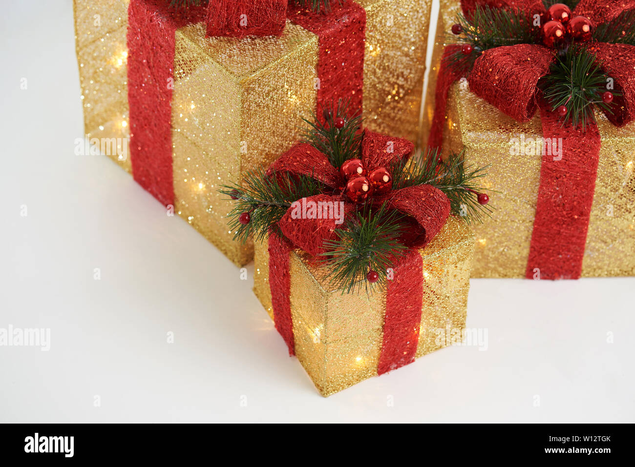 Gift boxes background. Gold glowing Christmas  decorated presents. Stock Photo