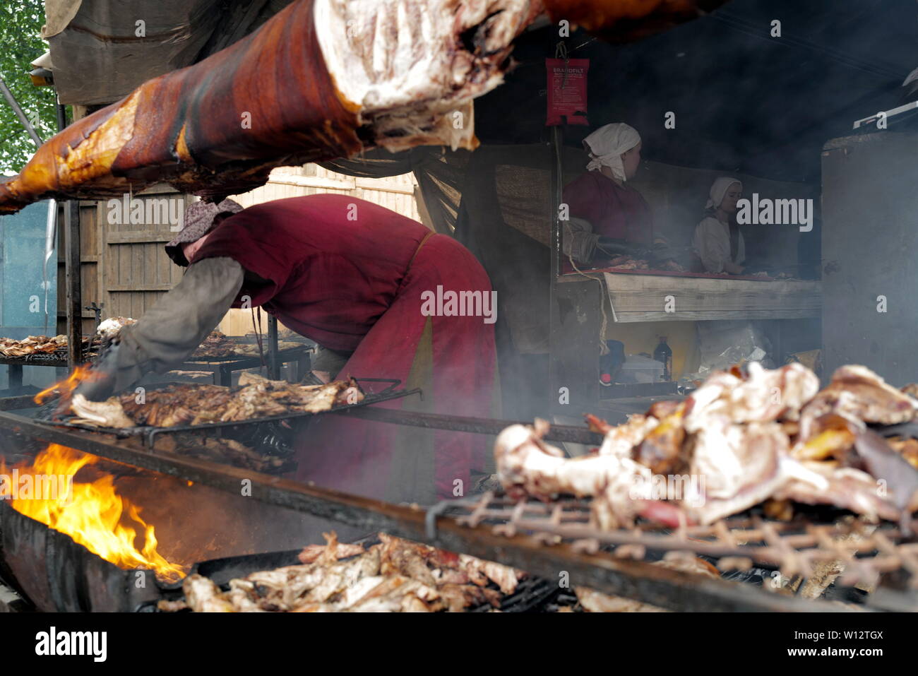 Turku, Finland. 29th June, 2019. Vendors prepare roast pork with ancient recipe in Turku, southwestern Finland, on June 29, 2019. The annual Medieval Market, one of the largest historical events in Finland, is held in Turku from June 27 to June 30. Modern people can enjoy ancient music and dance, historical street plays, traditional food and handicrafts during the event. Credit: Zhang Xuan/Xinhua/Alamy Live News Stock Photo