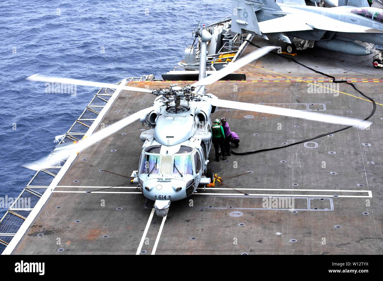 190627-N-HA101-0388 PACIFIC OCEAN (June 27, 2019) Sailors fuel an MH-60S Sea Hawk helicopter assigned to the “Indians” of Helicopter Sea Combat Squadron (HSC) 6 on the flight deck of the aircraft carrier USS Nimitz (CVN 68). Nimitz is currently underway conducting routine operations. (U.S. Navy photo by Mass Communication Specialist 3rd Class Jessica Tukes) Stock Photo