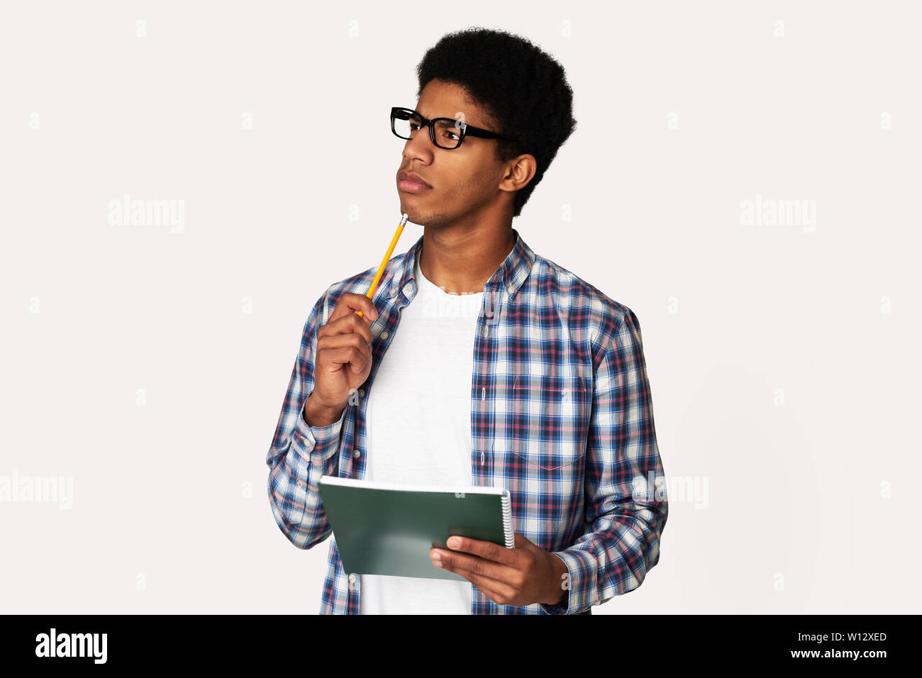 African-American Thoughtful Nerd Thinking about Test in Studio Stock Photo